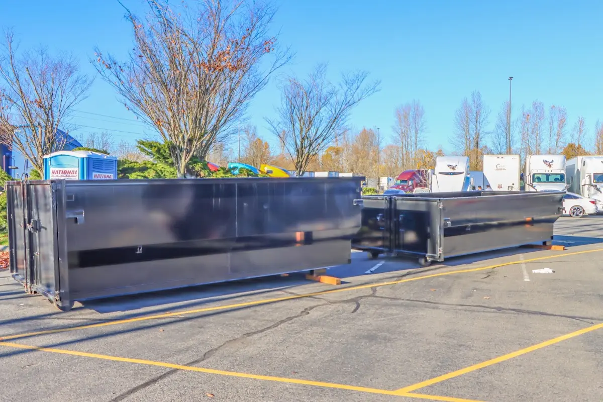 Professional dumpster rental service with roll-off container on residential driveway in Harvard